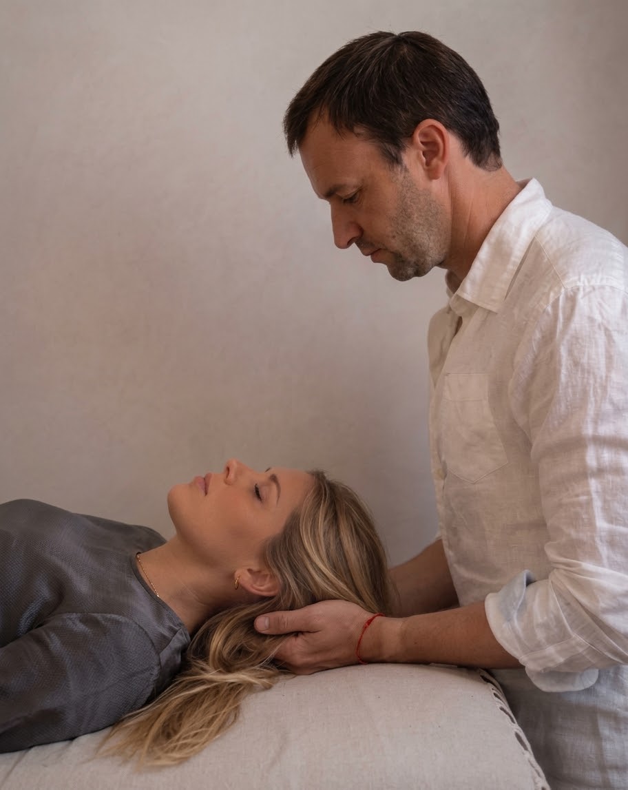 Fabien Joutel soutient la tête d’une cliente allongée pendant une séance de Reiki